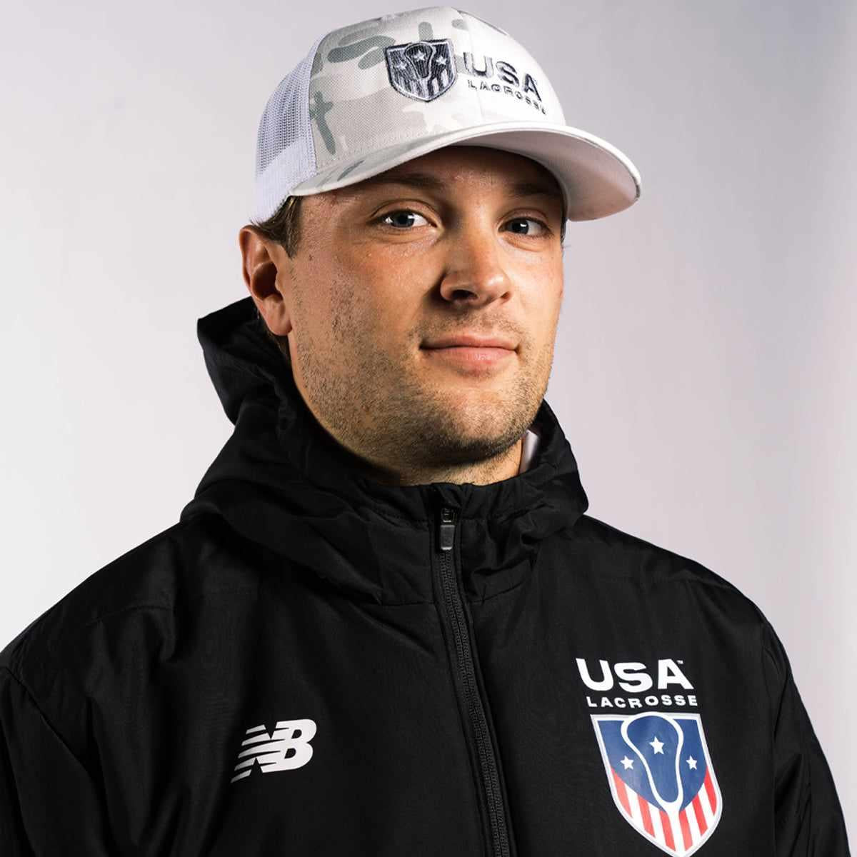 Man in USA jacket and cap, looking forward.