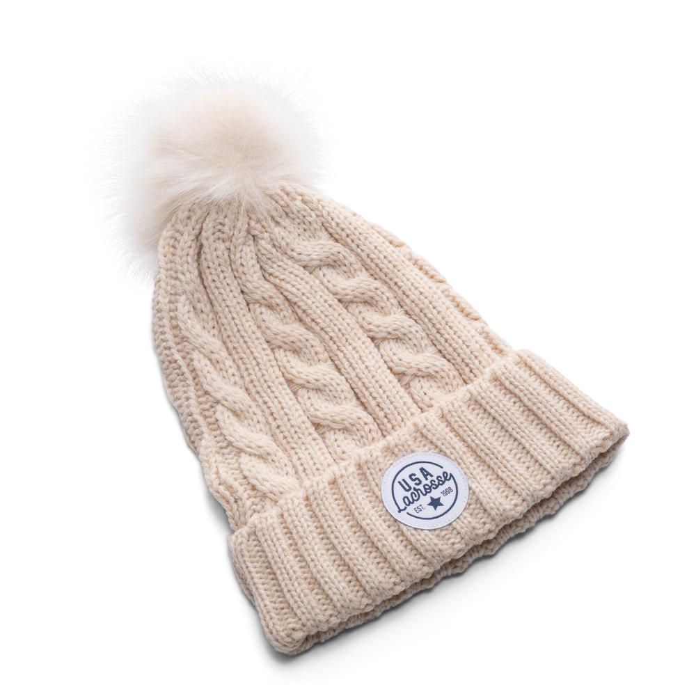 Beige knitted beanie with pom-pom and logo patch.