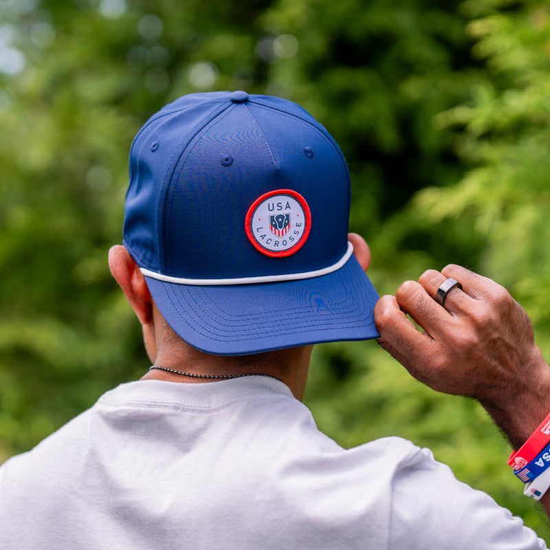 Man seen from behind adjusting a royal blue USA Lacrosse rope hat